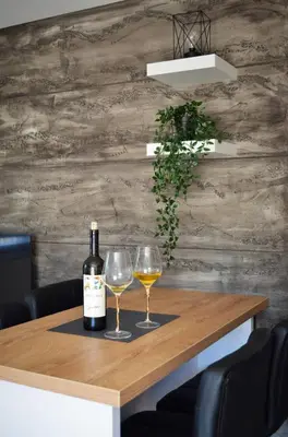 a bottle of wine and two glasses on a table at Penthaus apartman NOVAK in Vrnjci