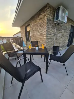 a patio with a table and chairs on a balcony at Penthaus apartman NOVAK in Vrnjci