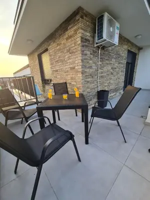 a patio with a table and chairs and a heater at Penthaus apartman NOVAK in Vrnjci