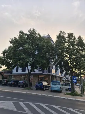 a building with cars parked on the side of a street at Penthaus apartman NOVAK in Vrnjci