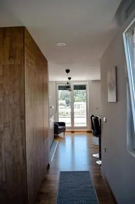 a living room with a large wooden cabinet and a hallway at Penthaus apartman NOVAK in Vrnjci