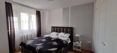 a bedroom with a bed and a large window at Symphony in Pirot
