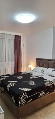 a bedroom with a bed with a black and white blanket at Symphony in Pirot