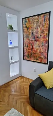 a living room with a couch and a large painting on the wall at Symphony in Pirot