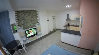 a living room with a tv and a kitchen at Cozy Quiet Apartment Nis in Niš
