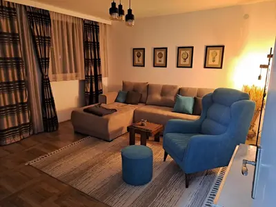 a living room with a couch and a blue chair at Hedonic apartment in Ćuprija