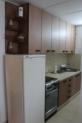 a kitchen with wooden cabinets and a refrigerator at Hedonic apartment in Ćuprija