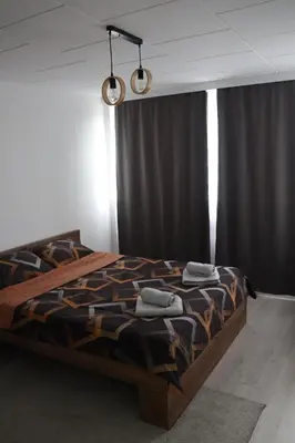 a bedroom with a bed in a room with curtains at Hedonic apartment in Ćuprija