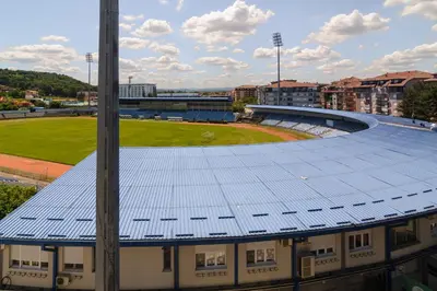 a building with a blue roof with a stadium at Gracija in Jagodina