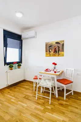 a white dining room with a table and chairs at Gracija in Jagodina