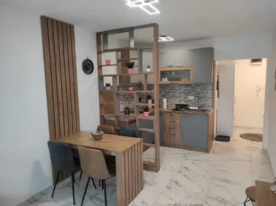 a kitchen and dining room with a wooden table and chairs at Cera exclusive apartment in Soko Banja