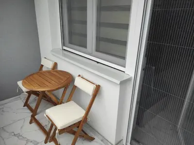 two chairs and a table next to a window at Cera exclusive apartment in Soko Banja