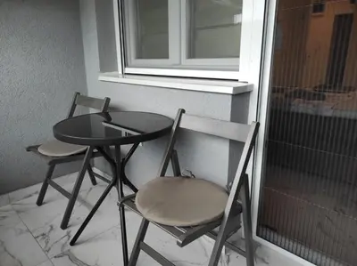 two chairs and a table next to a window at Cera exclusive apartment in Soko Banja