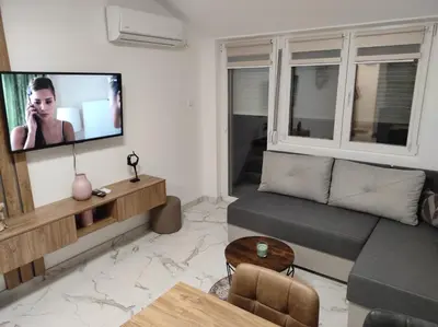 a living room with a couch and a flat screen tv at Cera exclusive apartment in Soko Banja