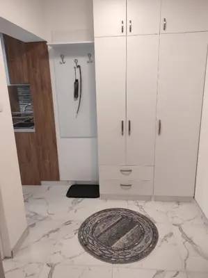 a kitchen with white cabinets and a marble floor at Cera exclusive apartment in Soko Banja