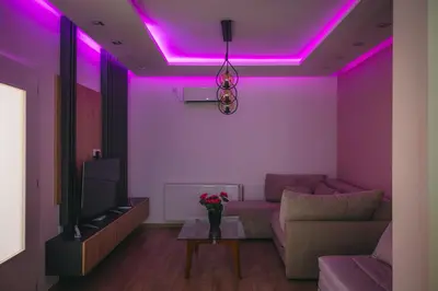 a living room with pink lights on the ceiling at Apartman Dias in Niš