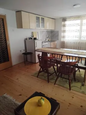 a kitchen and dining room with a table and chairs at Apartman Ristić in Vranje
