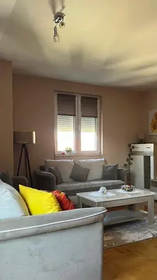 a living room with a couch and a table at Lily Cozy Apartment in Niš