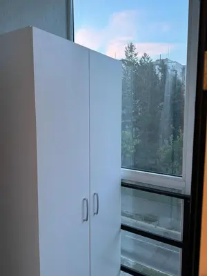 a white cabinet in front of a window at Loli apartman 2 in Kraljevo