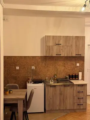 a kitchen with a table and a white refrigerator at Loli apartman 2 in Kraljevo