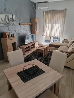 a living room with a wooden table and chairs at Apartman Sofija in Vrnjačka Banja