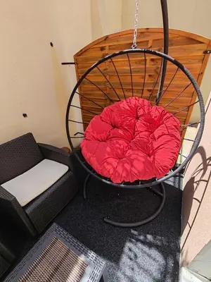 a red pillow sitting in a round chair at Apartman Sofija in Vrnjačka Banja