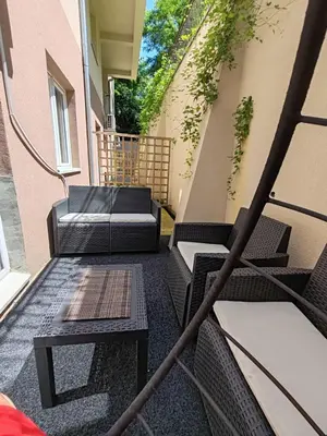a balcony with two chairs and a table on a building at Apartman Sofija in Vrnjačka Banja
