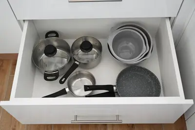 a drawer filled with pots and pans in a kitchen at Apartman Vera 8 VRNJAČKA BANJA in Vrnjačka Banja