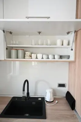 a kitchen with a sink and a shelf with dishes at Apartman Vera 8 VRNJAČKA BANJA in Vrnjačka Banja