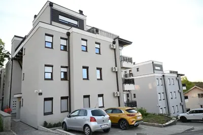 two cars parked in a parking lot in front of a building at Apartman Vera 8 VRNJAČKA BANJA in Vrnjačka Banja