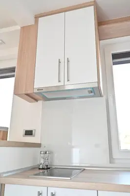 a kitchen with white cabinets and a sink at Apartman Vera 8 VRNJAČKA BANJA in Vrnjačka Banja