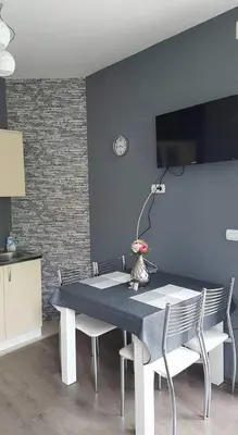 a dining room with a table and chairs and a wall at Apartman LUKA 2 in Soko Banja