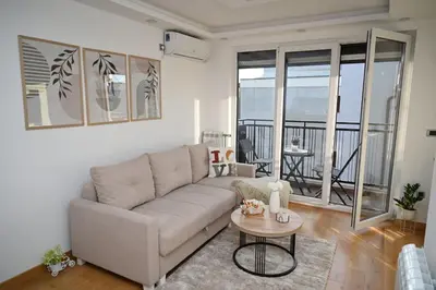 a living room with a couch and a table at Apartman Lokica S Vrnjačka Banja in Vrnjačka Banja