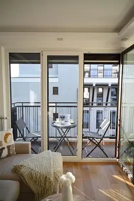 a living room with a balcony with a table and chairs at Apartman Lokica S Vrnjačka Banja in Vrnjačka Banja