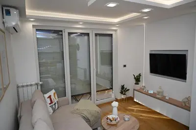 a living room with a couch and a flat screen tv at Apartman Lokica S Vrnjačka Banja in Vrnjačka Banja