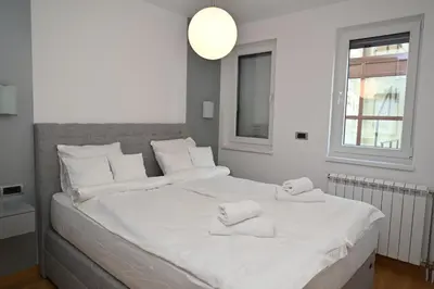 a bedroom with a large white bed with white pillows at Apartman Aleksa 5 VRNJAČKA BANJA in Vrnjačka Banja