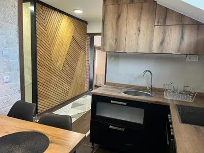 a kitchen with a sink and a table with chairs at DeFakto in Vrnjačka Banja