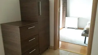 a wooden dresser in a room with a mirror at DeFakto in Vrnjačka Banja