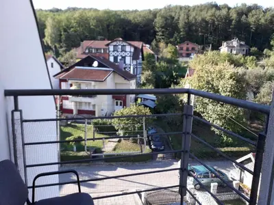 a balcony with a view of a house at DeFakto in Vrnjačka Banja
