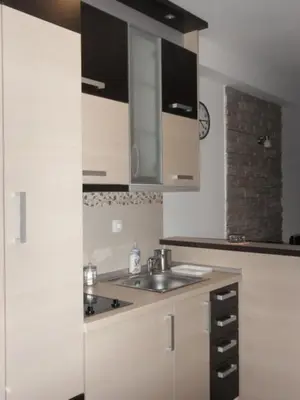 a kitchen with white cabinets and a sink at Apartman Sanja in Vrnjačka Banja
