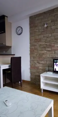 a room with a desk and a clock on a wall at Apartman Sanja in Vrnjačka Banja