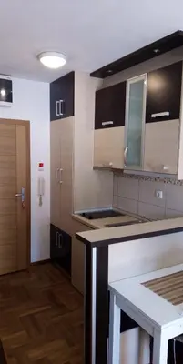 a kitchen with brown cabinets and a counter top at Apartman Sanja in Vrnjačka Banja