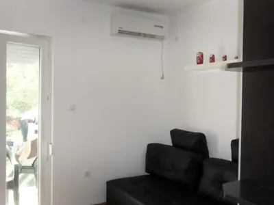 a living room with a black couch and a window at Apartman Sanja in Vrnjačka Banja