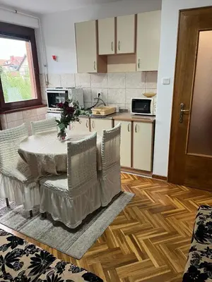a kitchen with a table and chairs in a kitchen at Apartman Sanja 3 in Vrnjačka Banja