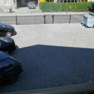 a shadow of two cars parked in a parking lot at Apartman Sanja 3 in Vrnjačka Banja