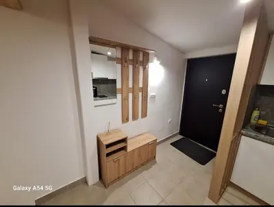 a bathroom with a wooden cabinet and a door at Apartman Centrala in Pirot