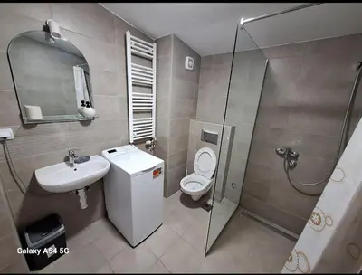 a bathroom with a toilet and a sink and a shower at Apartman Centrala in Pirot