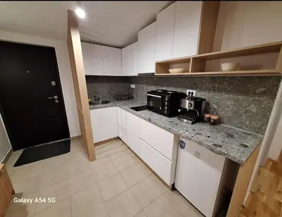 a kitchen with white cabinets and a counter top with a microwave at Apartman Centrala in Pirot