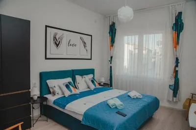 a bedroom with a blue bed with a blue blanket at Jes Apartments in Leskovac