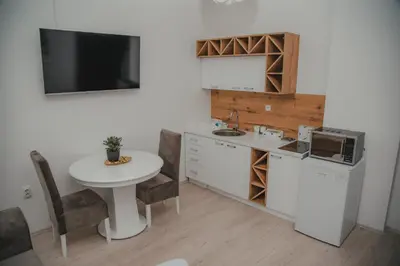 a kitchen with a table and a sink and a microwave at Jes Apartments in Leskovac